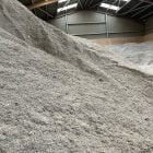 Pile of EnviroBed® livestock bedding in a large indoor facility.