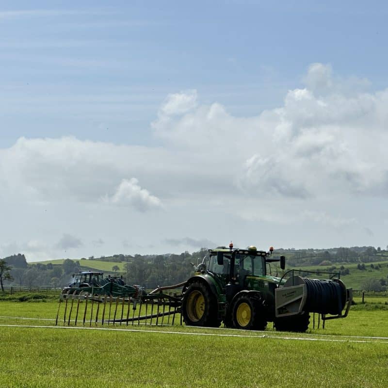 Tractor applying slurry inoculant to improve nutrient retention in fields.