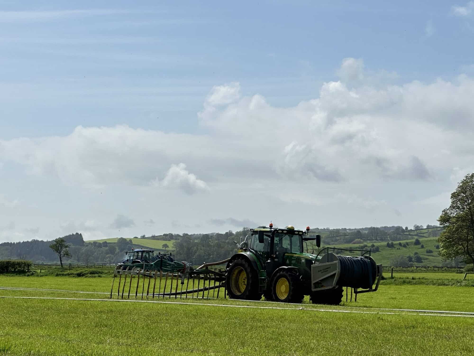 Tractor applying slurry inoculant to improve nutrient retention in fields.