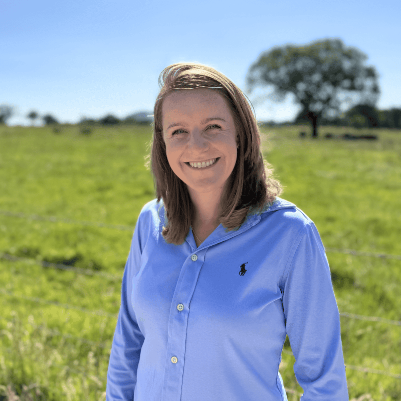 Smiling woman in blue shirt outdoors for EnviroSystems team.